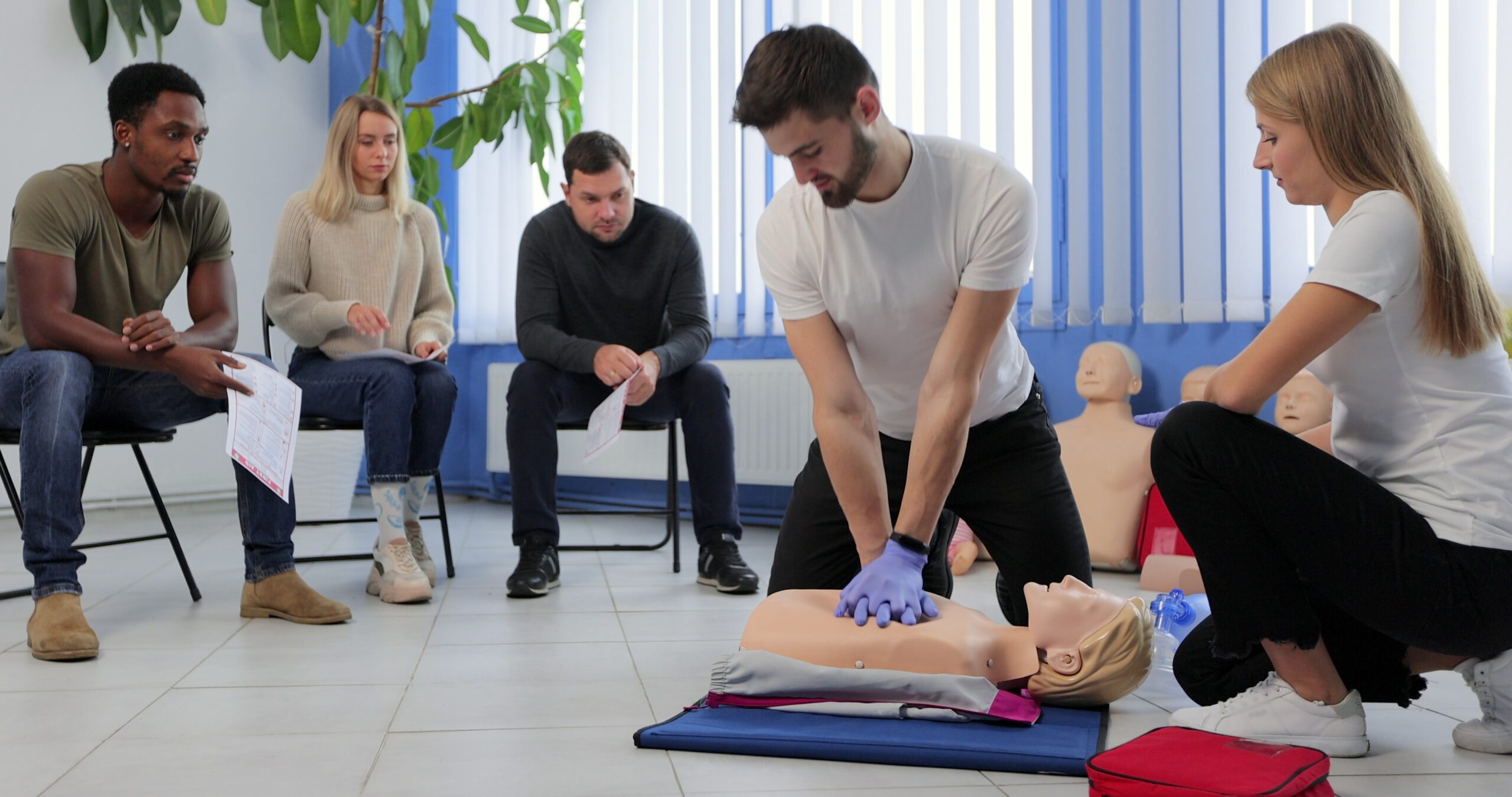 Instructor,Demonstrating,Cpr,On,Mannequin,At,First,Aid,Training,Course.